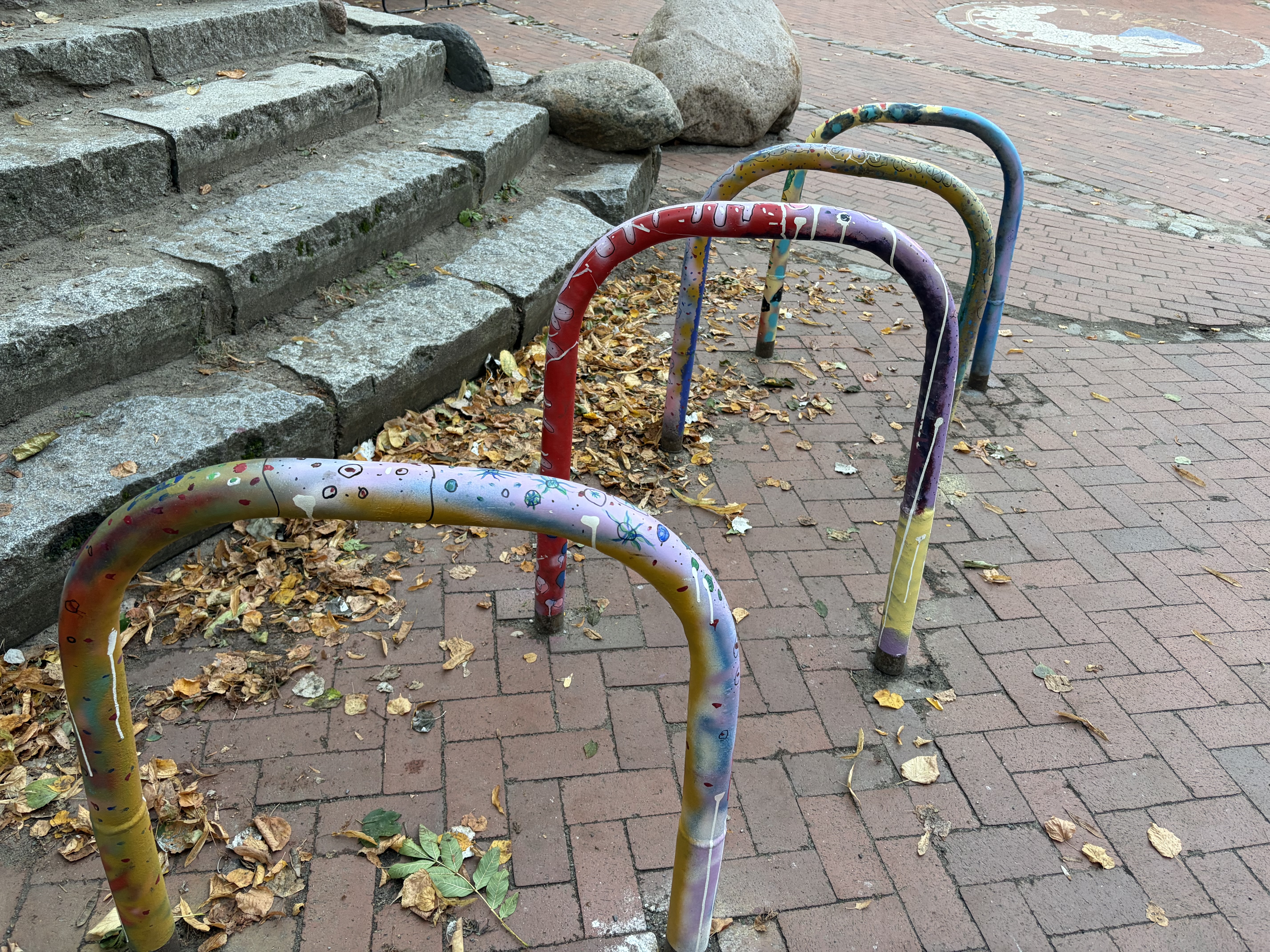 Bunt bemalte Fahrradständer neben den Steinstufen auf unserem Schulhof